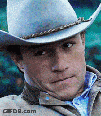 A Close Up Of A Man Wearing A Cowboy Hat And Jacket GIF