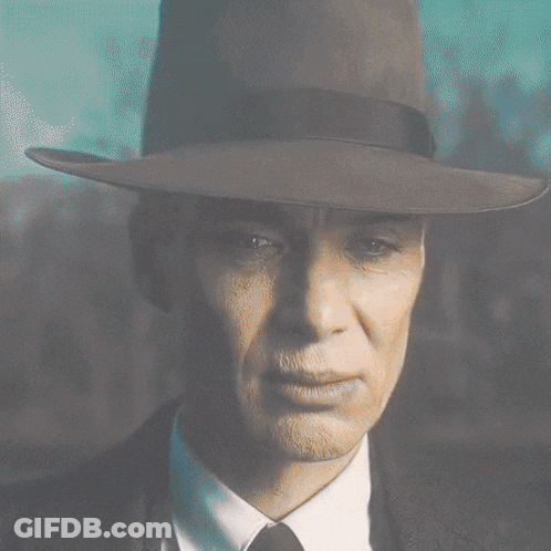 A Close Up Of A Man Wearing A Fedora And Tie GIF