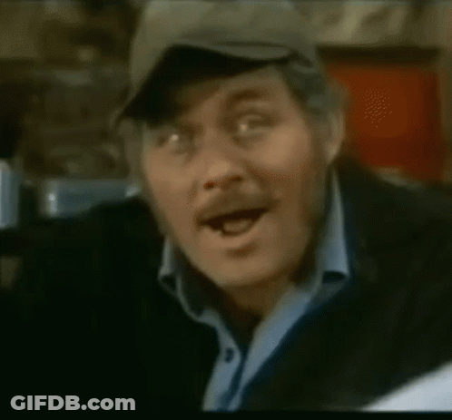 A Close Up Of A Man Wearing A Hat And A Blue Shirt GIF