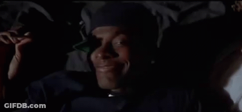 A Close Up Of A Man Wearing A Hat And A Jacket In The Dark . GIF