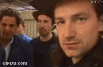 A Close Up Of A Man Wearing A Hat And Earrings Making A Funny Face . GIF