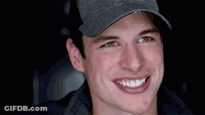 A Close Up Of A Man Wearing A Hat And Smiling At The Camera . GIF
