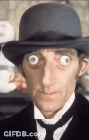 A Close Up Of A Man Wearing A Hat And Tie With His Eyes Wide Open . GIF