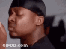 A Close Up Of A Man Wearing A Headband And A Black Shirt With His Eyes Closed . GIF