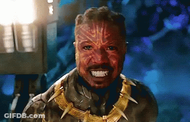 A Close Up Of A Man Wearing A Mask And A Necklace With Sharp Teeth . GIF