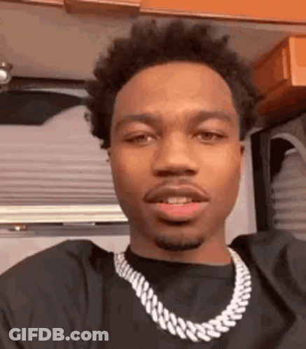 A Close Up Of A Man Wearing A Necklace . GIF