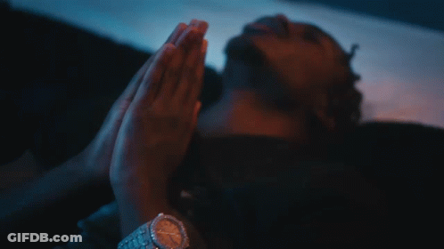 A Close Up Of A Man Wearing A Necklace And A Cross GIF