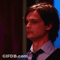 A Close Up Of A Man Wearing A Tie And Sweater . GIF