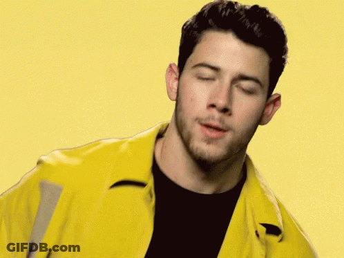 A Close Up Of A Man Wearing A Yellow Jacket And A Black Shirt With His Eyes Closed . GIF