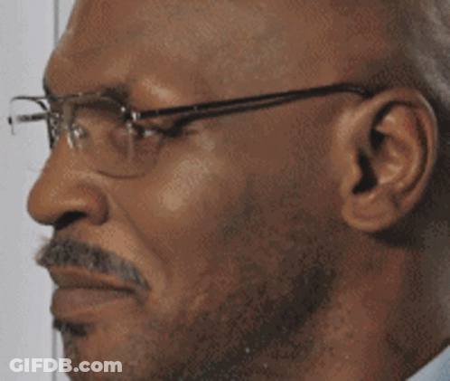 A Close Up Of A Man Wearing Glasses And A Beard GIF
