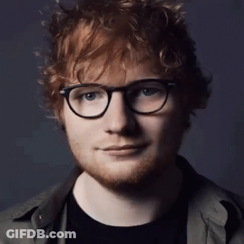 A Close Up Of A Man Wearing Glasses And A Black Shirt GIF