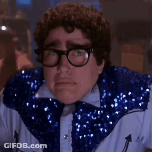 A Close Up Of A Man Wearing Glasses And A Blue Sequined Jacket . GIF