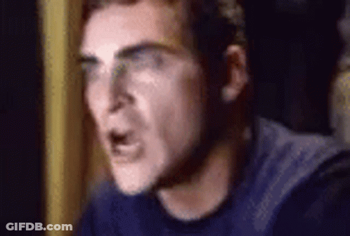 A Close Up Of A Man Wearing Glasses And A Blue Shirt Making A Funny Face . GIF