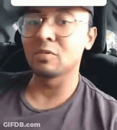 A Close Up Of A Man Wearing Glasses And A Hat GIF