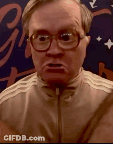 A Close Up Of A Man Wearing Glasses And A Jacket With The Letter G In The Background GIF