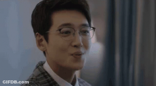 A Close Up Of A Man Wearing Glasses And A Plaid Jacket . GIF
