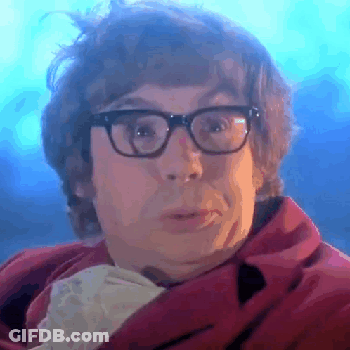 A Close Up Of A Man Wearing Glasses And A Red Jacket GIF
