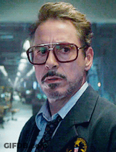 A Close Up Of A Man Wearing Glasses And A Suit And Tie . GIF