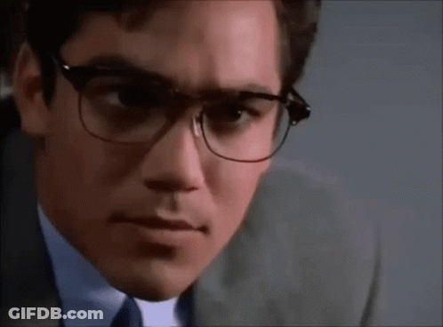 A Close Up Of A Man Wearing Glasses And A Suit And Tie . GIF
