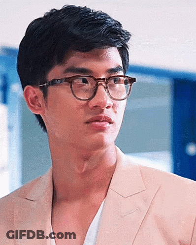 A Close Up Of A Man Wearing Glasses And A Tan Suit Jacket GIF