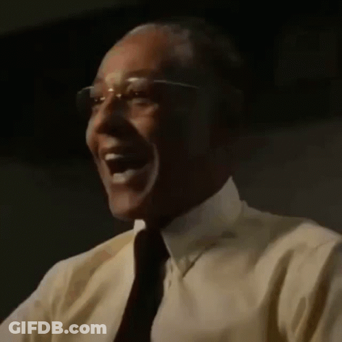 A Close Up Of A Man Wearing Glasses And A Yellow Shirt Laughing . GIF