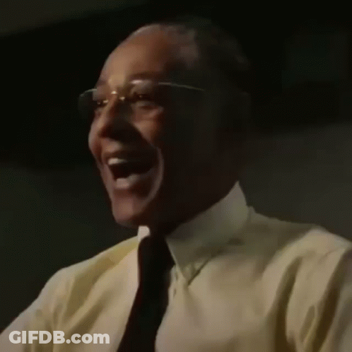A Close Up Of A Man Wearing Glasses And A Yellow Shirt Laughing . GIF