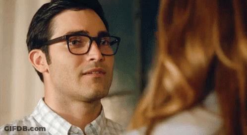A Close Up Of A Man Wearing Glasses Looking At A Woman . GIF