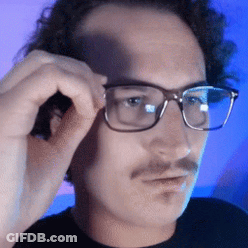 A Close Up Of A Man Wearing Glasses With A Mustache GIF
