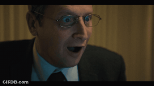A Close Up Of A Man Wearing Glasses With His Mouth Open GIF