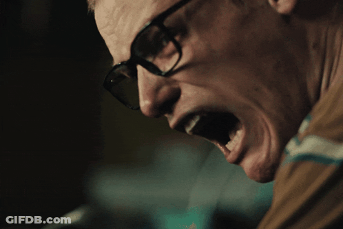 A Close Up Of A Man Wearing Glasses With His Mouth Wide Open GIF