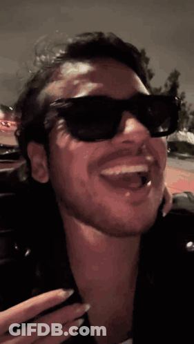 A Close Up Of A Man Wearing Sunglasses And A Leather Jacket GIF