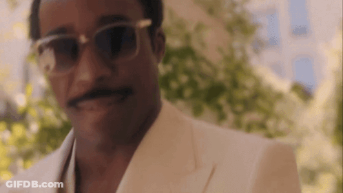 A Close Up Of A Man Wearing Sunglasses And A White Suit . GIF
