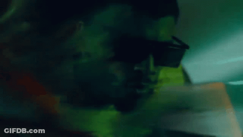A Close Up Of A Man Wearing Sunglasses In The Dark GIF