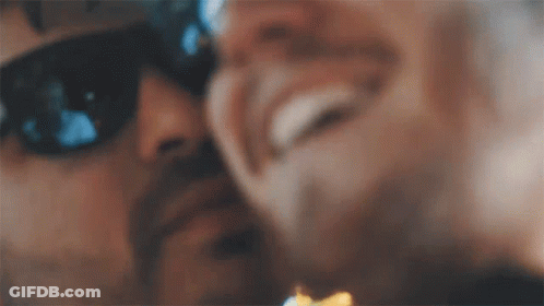 A Close Up Of A Man Wearing Sunglasses Kissing Another Man 'S Cheek . GIF