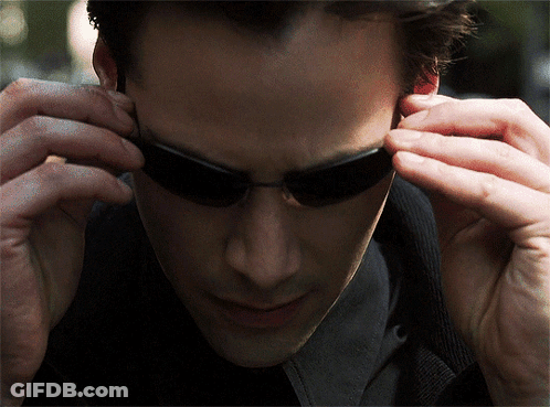 A Close Up Of A Man Wearing Sunglasses Looking Down GIF