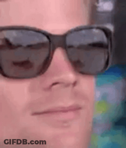 A Close Up Of A Man Wearing Sunglasses On His Face . GIF