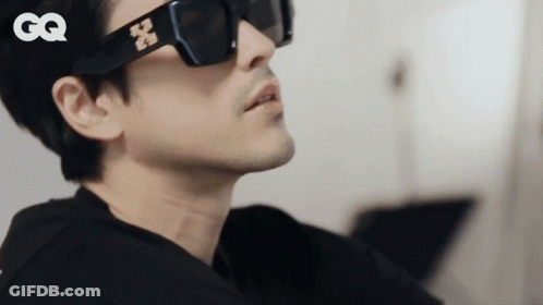 A Close Up Of A Man Wearing Sunglasses With The Gq Logo In The Corner GIF