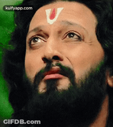 A Close Up Of A Man With A Beard And A V On His Forehead . GIF
