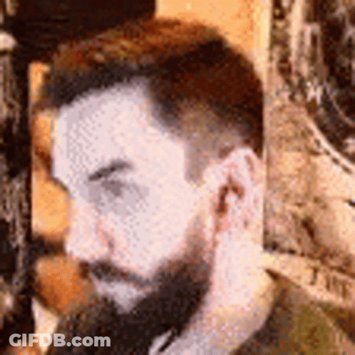 A Close Up Of A Man With A Beard Covering His Ear . GIF