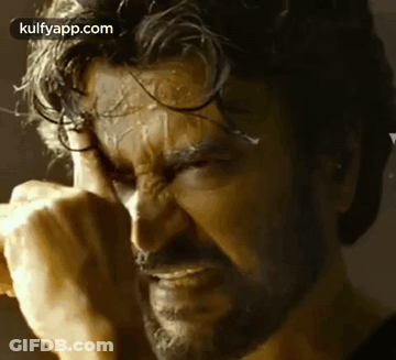A Close Up Of A Man With A Beard Covering His Face With His Hands . GIF
