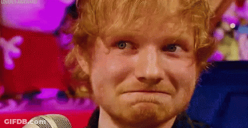 A Close Up Of A Man With A Beard Making A Funny Face While Standing In Front Of A Microphone . GIF