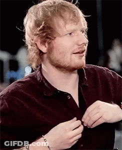 A Close Up Of A Man With A Beard Wearing A Maroon Shirt . GIF