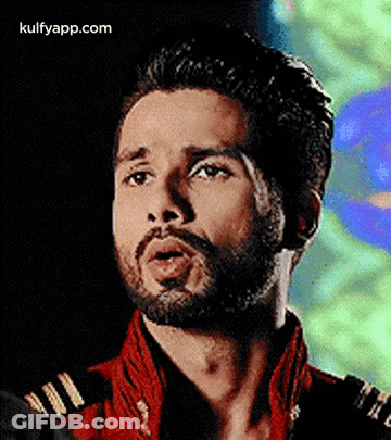 A Close Up Of A Man With A Beard Wearing A Red Jacket And A Black Shirt . GIF