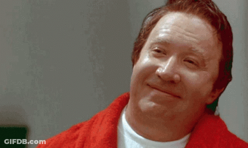 A Close Up Of A Man With A Beard Wearing A Red Jacket GIF