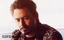 A Close Up Of A Man With A Beard Wearing A Shirt And Looking Down . GIF