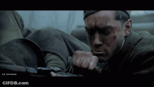 A Close Up Of A Man With Ex Hitman Written On The Bottom Right GIF