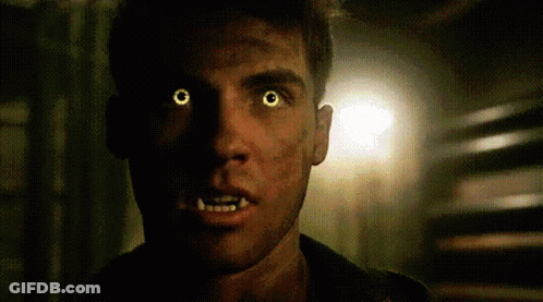 A Close Up Of A Man With Glowing Yellow Eyes And Teeth . GIF