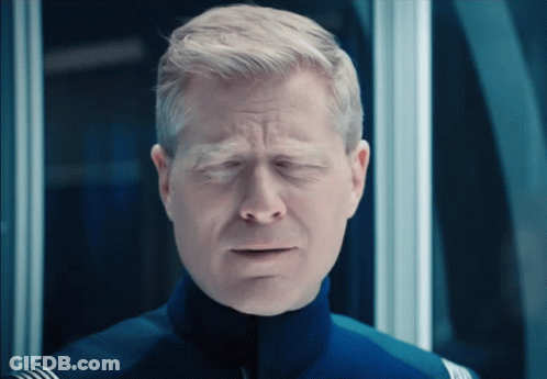 A Close Up Of A Man With His Eyes Closed In A Blue Uniform GIF