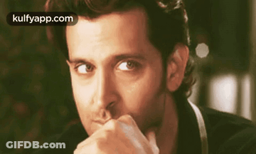 A Close Up Of A Man With His Hand On His Chin . GIF