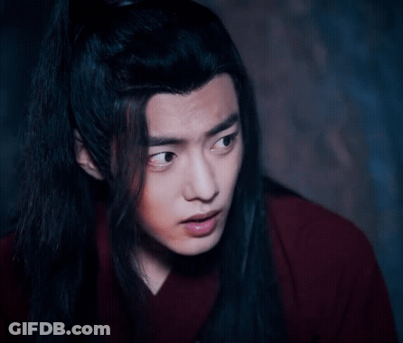 A Close Up Of A Man With Long Black Hair Wearing A Red Shirt . GIF